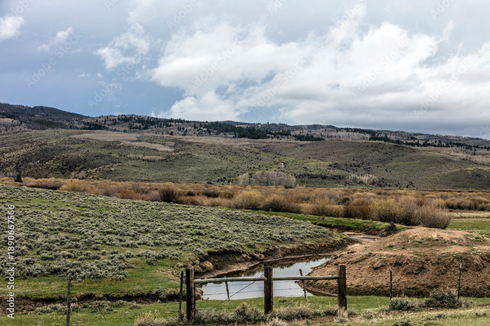 Naklejka premium Mountain Valley with Stream and Sagebrush Hills