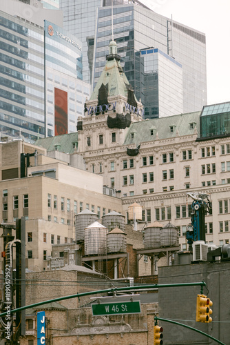 Photography Historic building stands among modern skyscrapers in New York City on West 46th