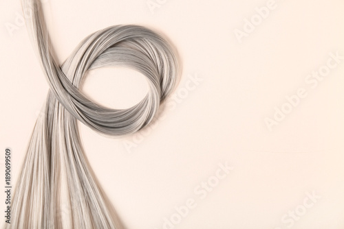 Foto Grey hair strand on beige background