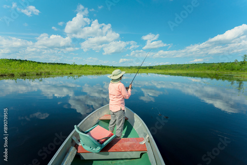 Foto Woman on a Maine lake fishing from boat.