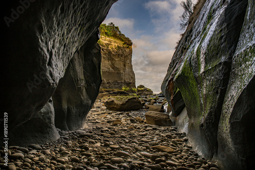 Exploring cliffside caves at Tongaporutu beach at  low tide on the Taranaki coastline