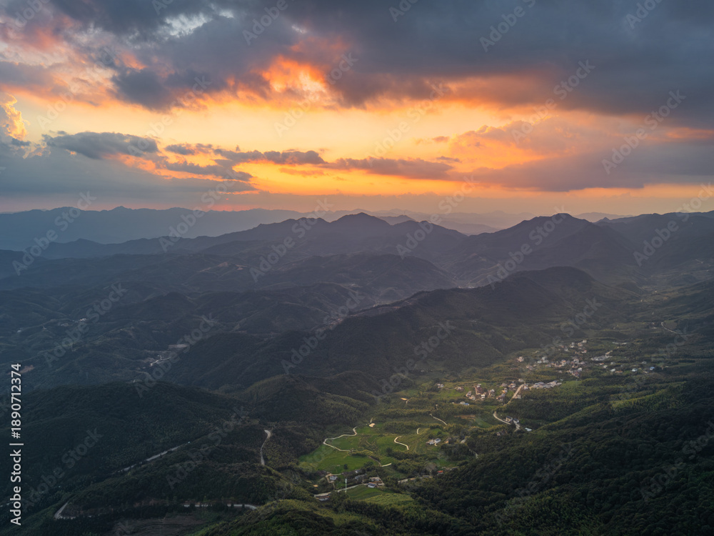Obraz premium Breathtaking Sunset Over Majestic Mountains and Valleys with Dramatic Clouds and Golden Sky