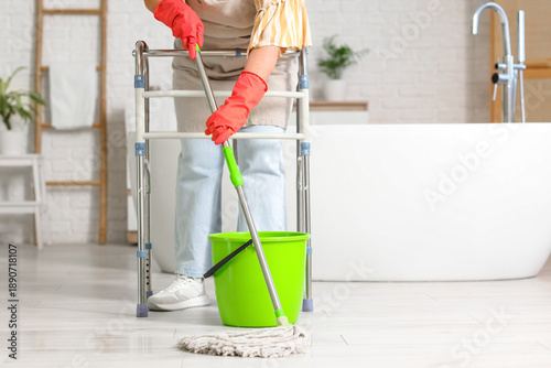 Woman with walker mopping f...