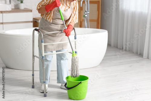 Woman with walker mopping f...