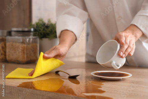 Woman wiping with rag spill...