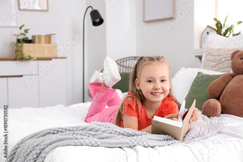 Cute little girl reading bo...