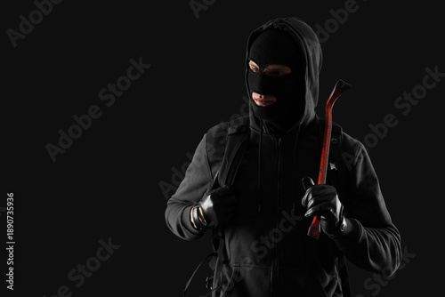 Male thief with crowbar on ...