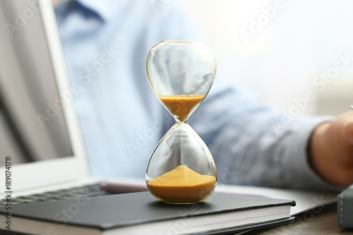 Hourglass with laptop and b...