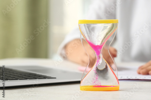 Hourglass with laptop near ...