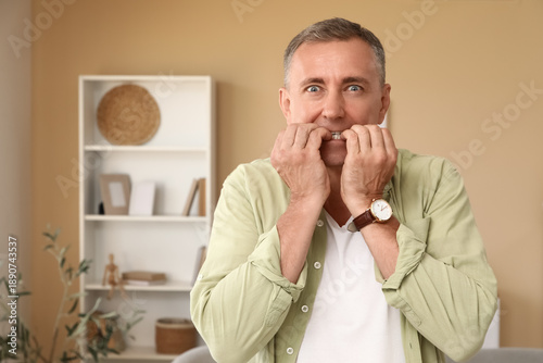 Worried mature man biting n...