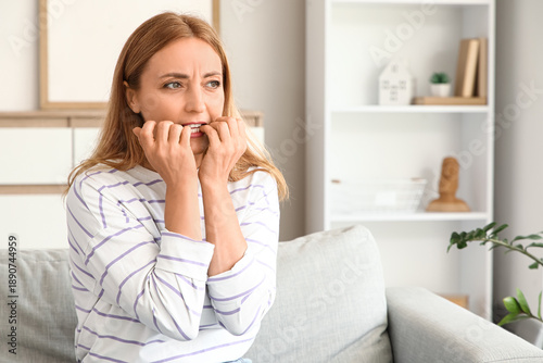Worried mature woman biting...