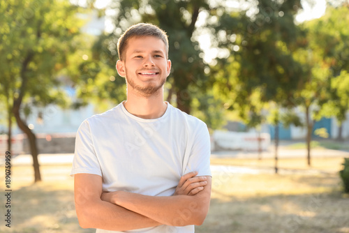 Handsome young happy man on sunny city street