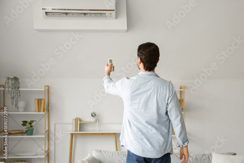 Handsome man turning on air...