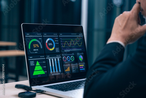 Close up Caucasian businessman sitting at desk using laptop with graph and statistical data on screen. business communication and digital interface technology digital composite image.