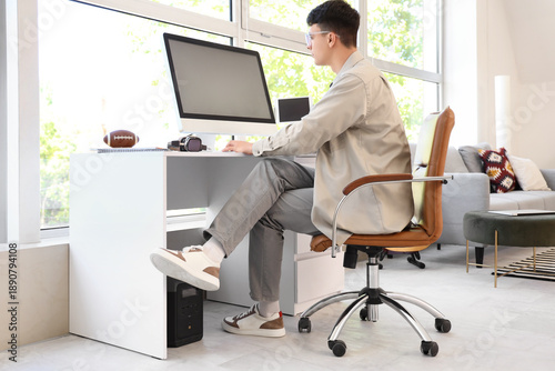 Young man using computer on...