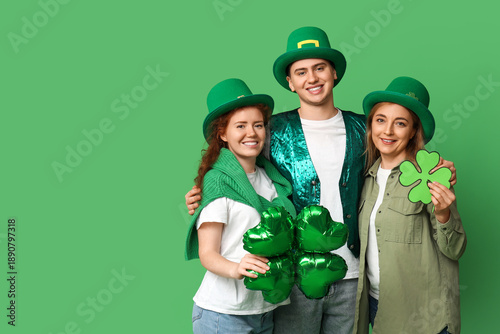 Happy friends with clovers on green background. St. Patrick's Day celebration