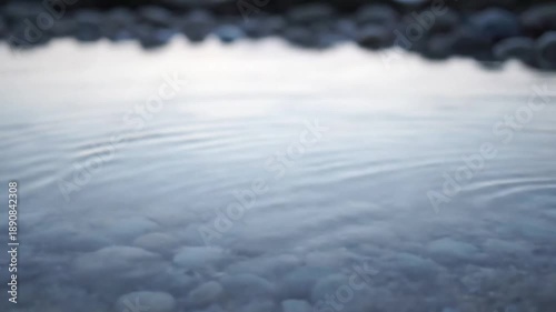 Subtle Breath A steady, eye-level shot observing the gentle, rhythmic expansion and contraction of the micro ripples, conveying the quiet, natural 'breathing' of the still water in an isolated tidal
