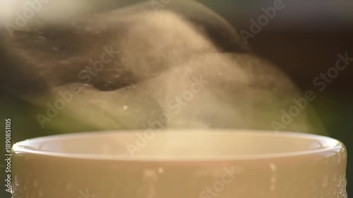 Close up of steaming hot beverage in a mug outdoors.