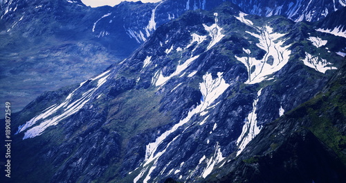 фотографія snowcovered mountain ridge with rocky slopes and patchy glacier remnants, crisp