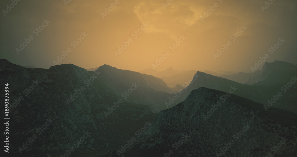 Obraz premium Layers of rugged mountains stretch across the horizon bathed in a warm golden glow. The atmosphere is serene, evoking a sense of peaceful solitude at dusk.