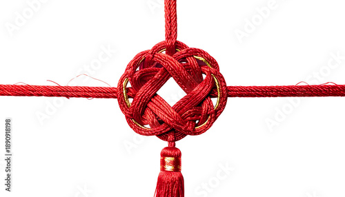 Intricate close-up of a red, decorative knot with gold accents and tassel, set against black