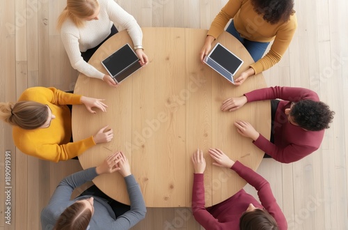Diverse group meeting around round table with tablets top view for business teamwork collaboration and technology concepts