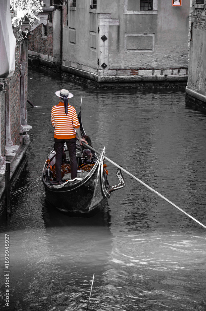 Obraz premium Italy, Venice, September 29, 2025, A gondolier in a red and white striped shirt is transporting tourists in Venice