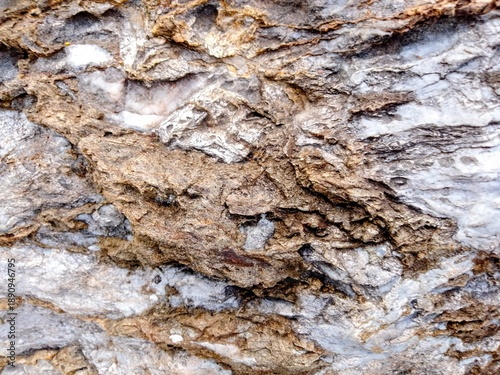 stone rock texture background with rough layered surface, white and brown mineral patterns, weathered geological formation, high detail abstract background for design, wallpaper, construction, nature,