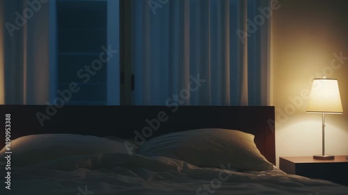 Cozy bedroom interior with a warm table lamp casting soft light on the bed and nightstand, creating a peaceful and relaxing atmosphere for sleeping and resting