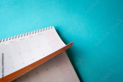 Table calendar on top of blue surface, copy space.