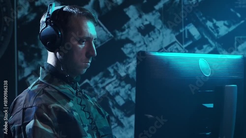 Soldier in a dimly lit military control room, intensely focused on multiple computer screens displaying crucial operational drone data.