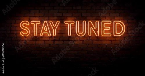 Vibrant neon stay tuned sign on brick wall at night