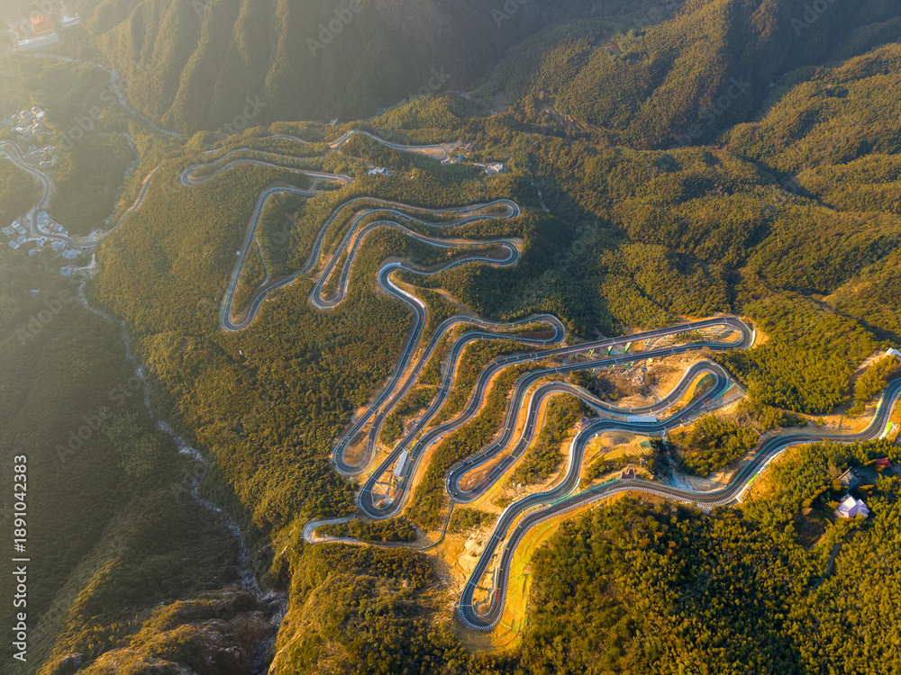 Obraz premium Aerial view of winding road through lush forests on Lushan Mountain in Jiangxi China