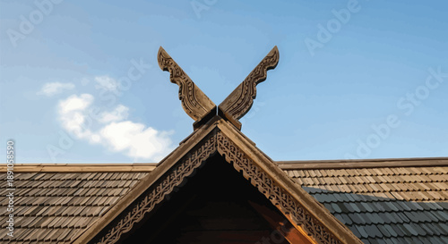 Intricately carved wooden dragon heads adorn the peak of a traditional stave church roof against a bright blue sky