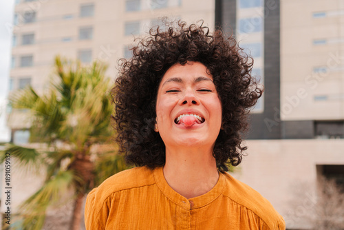 Foto A joyful young woman playfully sticking out her tongue while smiling brightly sh