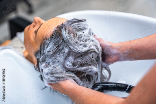 Fotografie Woman getting hair washed in a salon sink