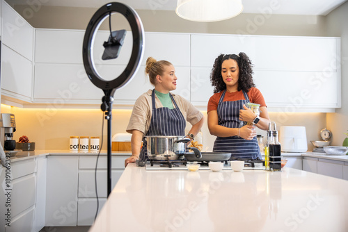 Valokuva Diverse female friends filming cooking demonstration in home kitchen with ring l