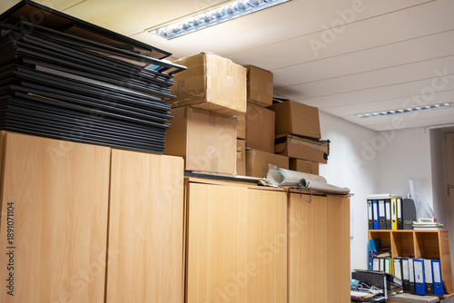 collection of cardboard boxes and metal filing cabinets filled with archival documents in an old, vintage office. The scene evokes a sense of history, organization, and storage of important papers.