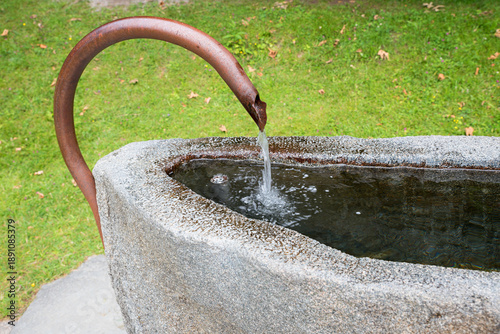 Obraz na plátne Stone trough with a curved copper tap