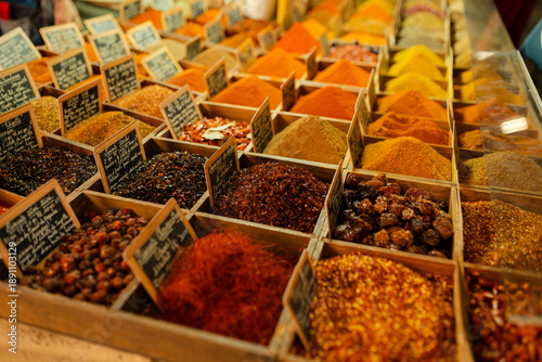 Photography Assorted colorful spices displayed in wooden boxes at a traditional food market
