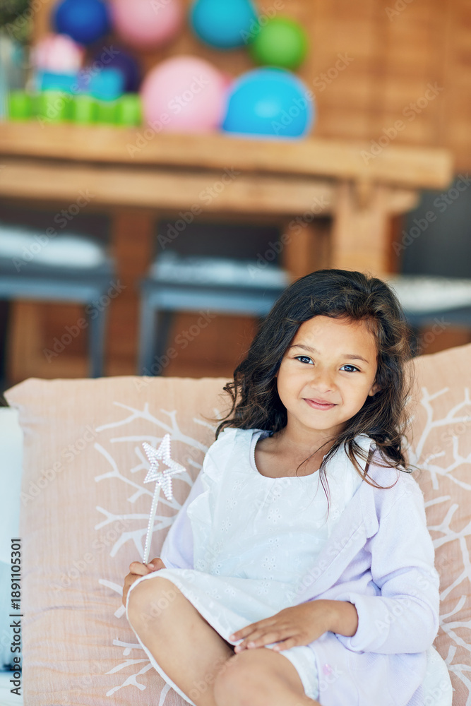 Fototapeta premium Happy, fairy wand and portrait of child in home for playing, pretend games and fantasy cosplay. House, childhood and girl with toy for princess dress up, birthday and fairytale outfit on sofa