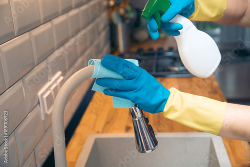 Using cleaning products for cleaning table in kitchen at home. Housekeeping, household chores.