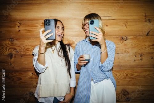 Startup team members laughing with phones during break