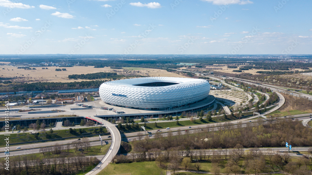 Fototapeta premium Munich, Germany - April 04, 2021: Drone flight over Football stadium Allianz Arena at sunny day