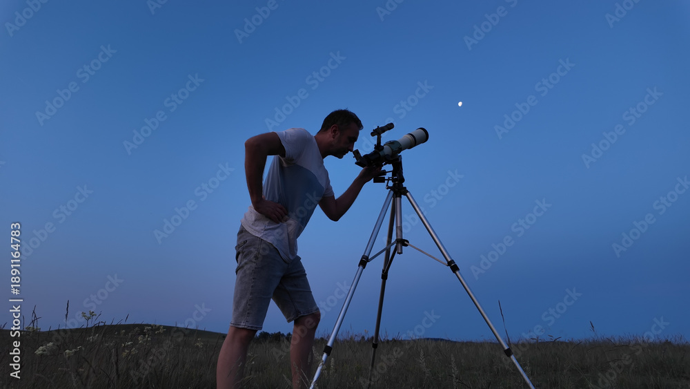 Fototapeta premium Amateur astronomer using telescope for watching stars, Moon, planets and other celestial objects from a field in nature.