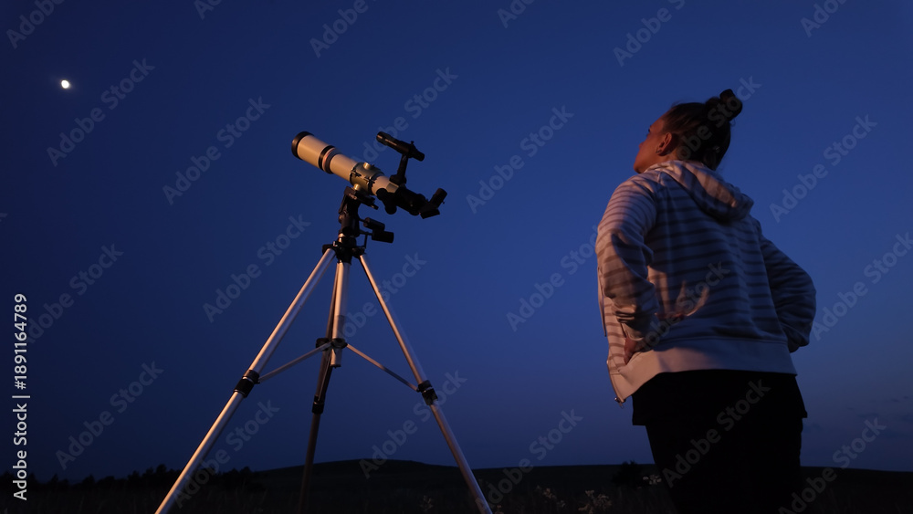 Fototapeta premium Amateur astronomer using telescope for watching stars, Moon, planets and other celestial objects from a field in nature.