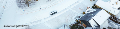 Fotografie Panorama aerial view subdivision near Parkway Boulevard in the midst of Winter Storm Fern rooflines, icy roads, sparse vehicle movement