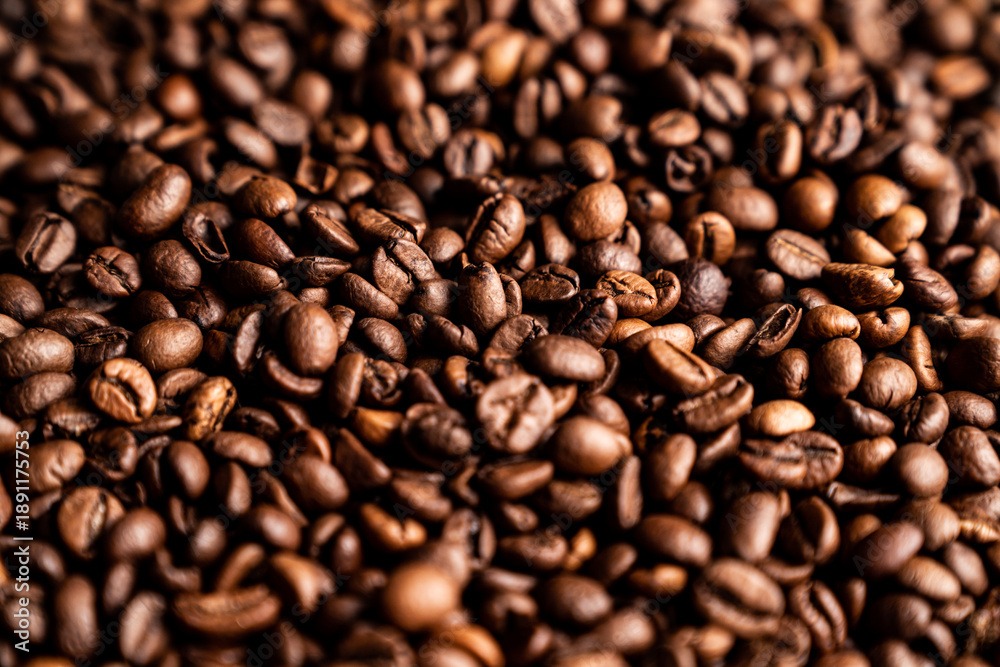 Fototapeta premium Freshly roasted coffee beans in a close-up view on a wooden surface