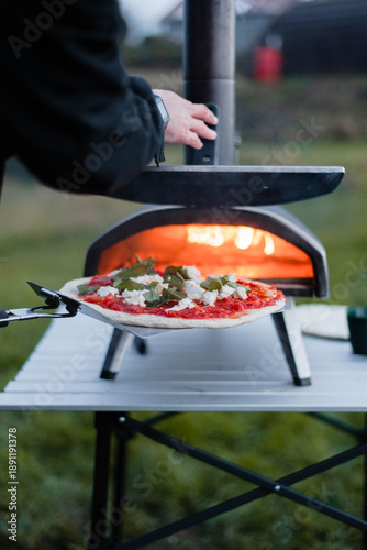 Pizza Being Placed in a Portable Oven Inside a Camper