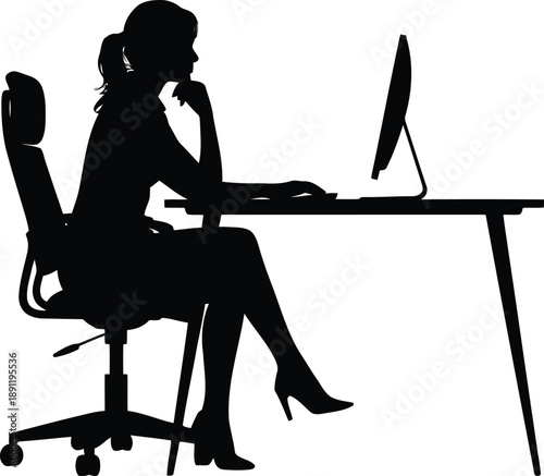 Female silhouette working diligently on a desktop computer at an ergonomic office desk in profile